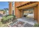 An inviting outdoor patio space with a concrete floor and a sliding glass door, surrounded by stone landscaping at 4281 S Salida Way # 8, Aurora, CO 80013