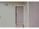 Neutral-colored front door with security features and a welcome mat on a light wood siding building at 12896 Ironstone Way # 203, Parker, CO 80134