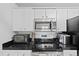 Close up on modern black countertops and stainless steel appliances in the kitchen at 12896 Ironstone Way # 203, Parker, CO 80134