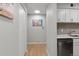 This hallway features wood-look floors, modern art, and a doorway to the kitchen space at 7455 E Quincy Ave # 204, Denver, CO 80237