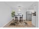 This kitchen features stainless steel appliances, a small table for eating, and wood-look floors at 7455 E Quincy Ave # 204, Denver, CO 80237