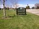 The Eastmoor Park sign is centered in the image with green grass and a few yellow dandelions surrounding it at 7455 E Quincy Ave # 204, Denver, CO 80237