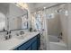 Bathroom features a blue vanity, white countertop and decorative floral curtain at 13023 Grant Cir # C, Thornton, CO 80241