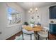 Bright dining area with a round table, modern chandelier, and large window at 13023 Grant Cir # C, Thornton, CO 80241