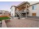 Spacious backyard with brick patio, landscaped garden beds, and a covered deck with string lights at 11100 Pastel Pt, Parker, CO 80134