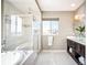 Bright bathroom featuring a soaking tub, a separate glass shower, and a double vanity at 11100 Pastel Pt, Parker, CO 80134