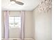 Neutral bedroom featuring decorative floral artwork, a ceiling fan, and large windows with pale purple drapes at 11100 Pastel Pt, Parker, CO 80134