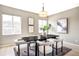 Neutral colored dining room with modern light fixture, large windows, and seating for six people at 11100 Pastel Pt, Parker, CO 80134