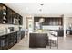 Kitchen with stainless steel appliances, dark cabinets, large island, granite countertops, and pendant lighting at 11100 Pastel Pt, Parker, CO 80134