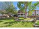 Spacious backyard featuring a patio, mature trees, and well-maintained lawn at 11431 W Lake Dr, Littleton, CO 80127