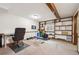 A basement with wooden beams, a fitness bike, weights, shelves and a desk setup at 11431 W Lake Dr, Littleton, CO 80127