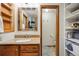 A well-lit bathroom with a granite countertop, custom wood cabinets, and an adjacent toilet and storage area at 11431 W Lake Dr, Littleton, CO 80127