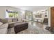 Cozy living room area featuring a comfortable gray sectional, ottoman, and access to the outdoors through sliding glass doors at 11431 W Lake Dr, Littleton, CO 80127