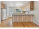 Bright kitchen featuring wood-look island, white appliances, wood cabinets, and lots of natural light at 3006 W 107Th Pl # D, Westminster, CO 80031