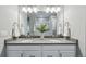 Bright bathroom boasts double vanity with gray countertop, white cabinets, and a large mirror at 1592 Maggie Mae Ln, Castle Rock, CO 80104