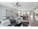Spacious living area with gray sectional, view into a well-lit kitchen, and modern accents at 1592 Maggie Mae Ln, Castle Rock, CO 80104