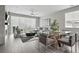 Open-concept living space with a gray sectional, modern dining set, and bright, airy ambiance at 1592 Maggie Mae Ln, Castle Rock, CO 80104