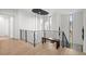 Bright hallway with hardwood floors, black railings, a stylish bench and a unique light fixture at 2821 E Cedar Ave # 17, Denver, CO 80209