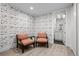 Sitting room featuring two comfortable chairs, modern wallpaper, and view into adjoining bathroom at 2821 E Cedar Ave # 17, Denver, CO 80209