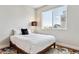 Bedroom features a colorful rug, modern lighting, and a large window offering natural light at 888 S Valentia St # 14-103, Denver, CO 80247