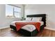 A cozy bedroom featuring a large window, a comfortable bed, and wood-look flooring at 888 S Valentia St # 14-103, Denver, CO 80247