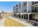 Row of modern townhomes featuring brick facade with lawn and common space at 888 S Valentia St # 14-103, Denver, CO 80247