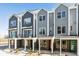 Row of modern townhomes featuring brick facade and covered porches at 888 S Valentia St # 14-103, Denver, CO 80247