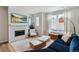 Comfortable living room with fireplace, large television, and lots of natural light at 888 S Valentia St # 14-103, Denver, CO 80247