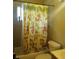 Cheerful bathroom with a whimsical monkey-themed shower curtain and tile surround at 6911 Weiman Ct, Commerce City, CO 80022