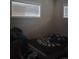 Cozy bedroom featuring two bright windows and comfortable furnishings at 6911 Weiman Ct, Commerce City, CO 80022