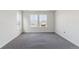 A bright bedroom with neutral carpet and large windows offering neighborhood views at 25254 E Warren Pl, Aurora, CO 80018