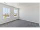 A bright bedroom with neutral carpet and large windows offering neighborhood views at 25254 E Warren Pl, Aurora, CO 80018