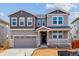 Charming two-story home boasts a covered porch, two-car garage, and attractive mixed-material facade at 25254 E Warren Pl, Aurora, CO 80018