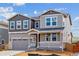 Charming two-story home boasts a covered porch, two-car garage, and attractive mixed-material facade at 25254 E Warren Pl, Aurora, CO 80018