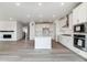 Spacious kitchen boasts a large center island, white cabinetry, stainless steel appliances, and LVP flooring at 25254 E Warren Pl, Aurora, CO 80018