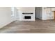 Open-concept living room featuring luxury vinyl plank flooring, a modern fireplace, and built-in shelves at 25254 E Warren Pl, Aurora, CO 80018