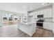 Bright, modern kitchen features stainless appliances, a spacious island, and sliding glass doors at 4464 Boone Cir, Brighton, CO 80601