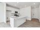Open concept kitchen features white cabinets, a large island, and stainless steel appliances at 4464 Boone Cir, Brighton, CO 80601