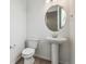 The home features a powder room with modern pedestal sink and an oval mirror at 4464 Boone Cir, Brighton, CO 80601