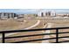 Balcony view with an iron railing overlooking a walking path and modern community buildings at 6153 N Ceylon St # 302, Denver, CO 80249