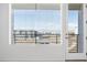 View from balcony showing city buildings and distant mountains through window blinds at 6153 N Ceylon St # 302, Denver, CO 80249