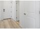 Inviting entryway featuring light wood floors and white doors, providing a clean and modern aesthetic at 6153 N Ceylon St # 302, Denver, CO 80249