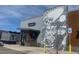 An exterior view of a commercial building with an artistic mural on the side at 6153 N Ceylon St # 302, Denver, CO 80249