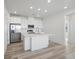 Bright, open-concept kitchen featuring white cabinets, island, and modern stainless steel appliances at 6153 N Ceylon St # 302, Denver, CO 80249