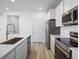 Well-lit kitchen featuring an island with a sink, stainless steel appliances and white cabinets at 6153 N Ceylon St # 302, Denver, CO 80249