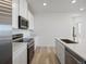 Well-lit kitchen featuring an island with a sink, stainless steel appliances and white cabinets at 6153 N Ceylon St # 302, Denver, CO 80249