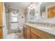 Bathroom with dual sinks, granite countertop, and shower-tub combo featuring neutral tile surround at 5048 Rocky Mountain Dr, Castle Rock, CO 80109
