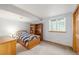 Finished basement bedroom with a wood-framed window, a bookshelf, and carpeted floors at 5048 Rocky Mountain Dr, Castle Rock, CO 80109