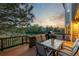 Enjoy outdoor dining on this spacious wood deck with a table and chairs overlooking a serene backyard at 5048 Rocky Mountain Dr, Castle Rock, CO 80109