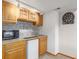 Basement wet bar with wooden cabinets, sink, microwave, mini-fridge, and dartboard at 5048 Rocky Mountain Dr, Castle Rock, CO 80109
